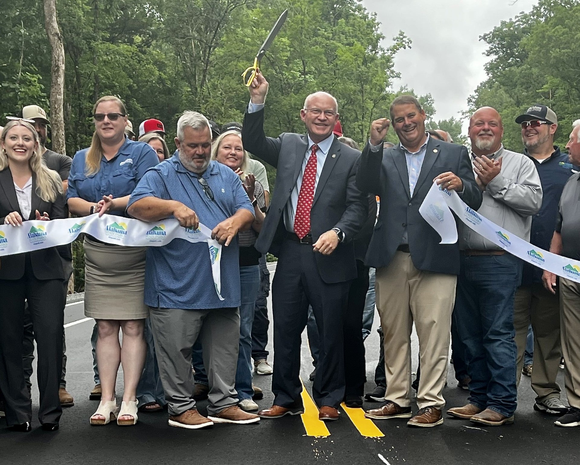 State Rep. David Standridge celebrates after cutting the ceremonial ribbon for the new access road at Rickwood Caverns State Park on Monday, June 8, 2026.